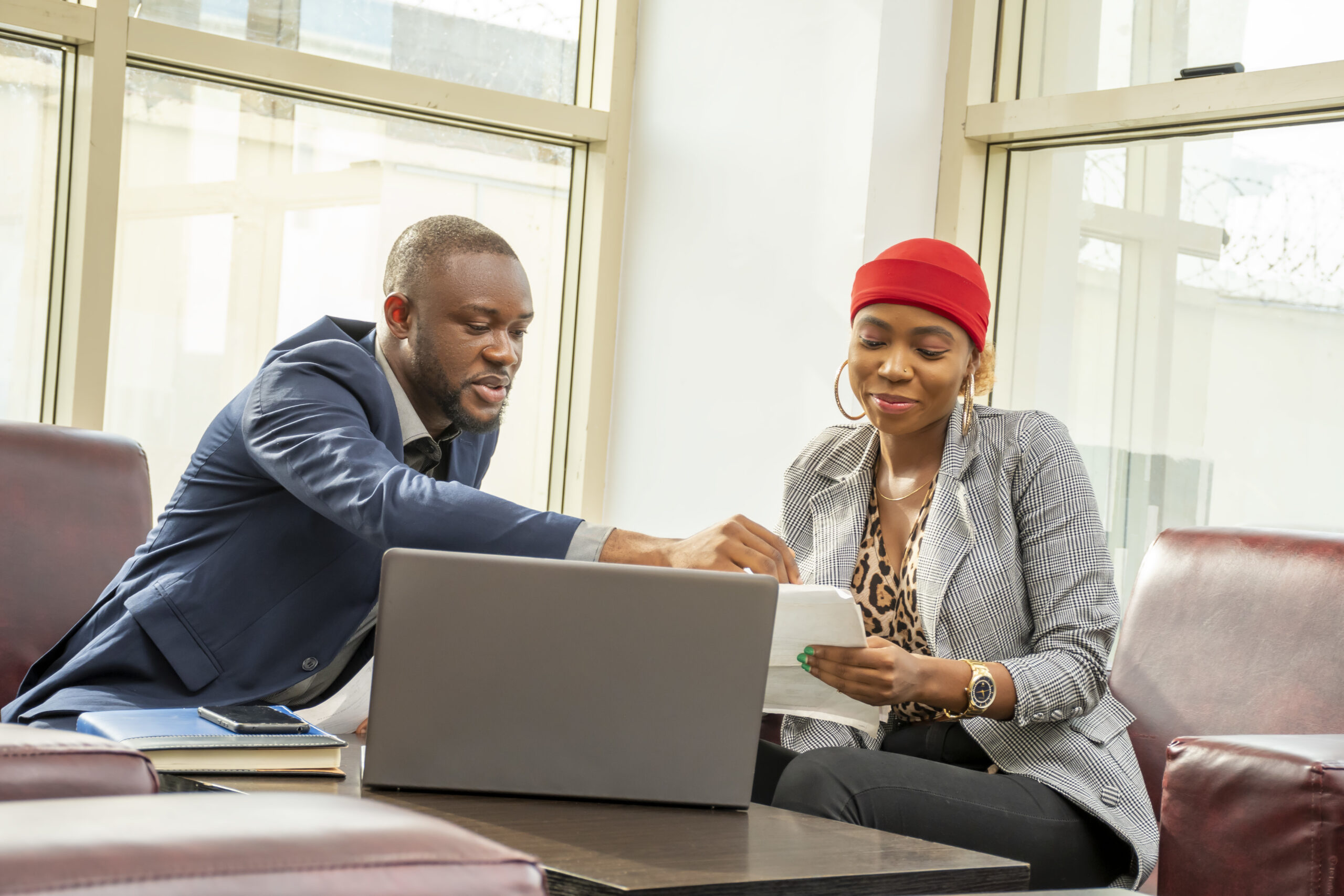 Young black businessman and woman going through some paperwork together